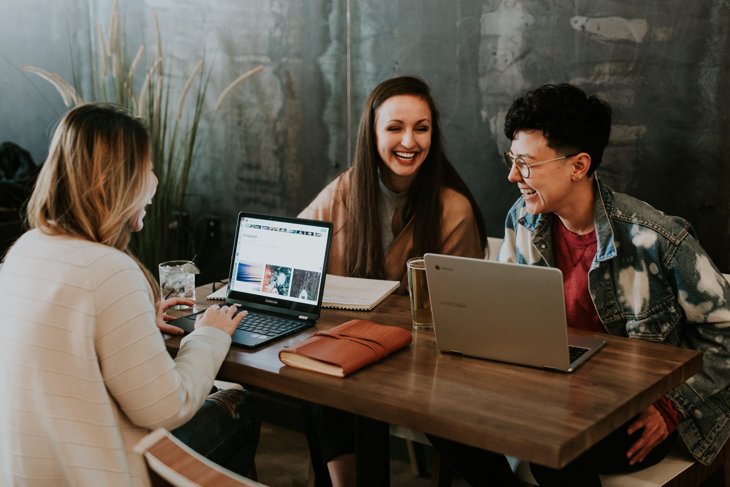 Three friends laughing at a table