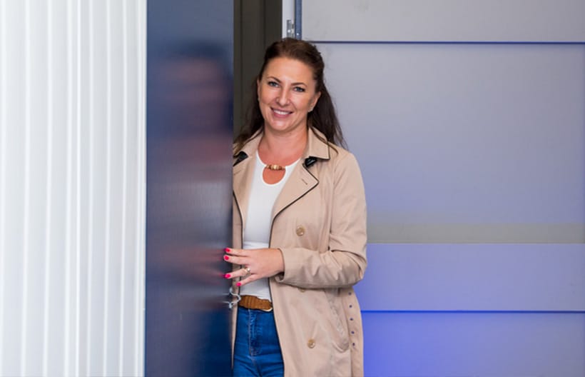 A woman happily standing at the entrance of a storage unit