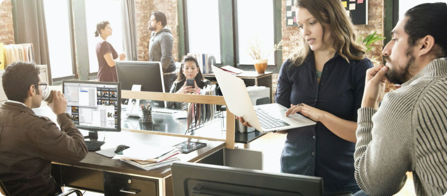 An office woman showing her laptop to a colleague