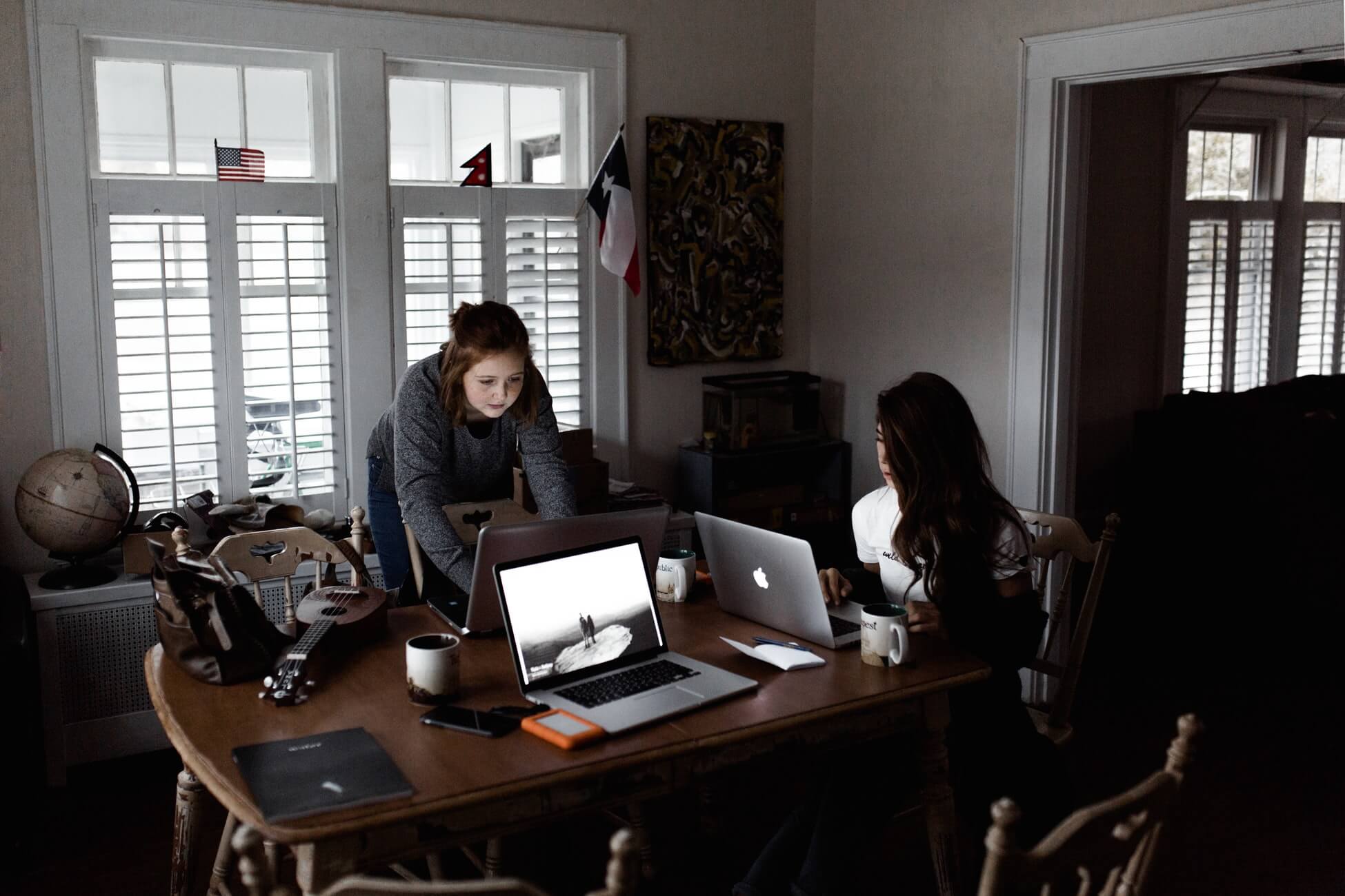 Two women working on their laptops