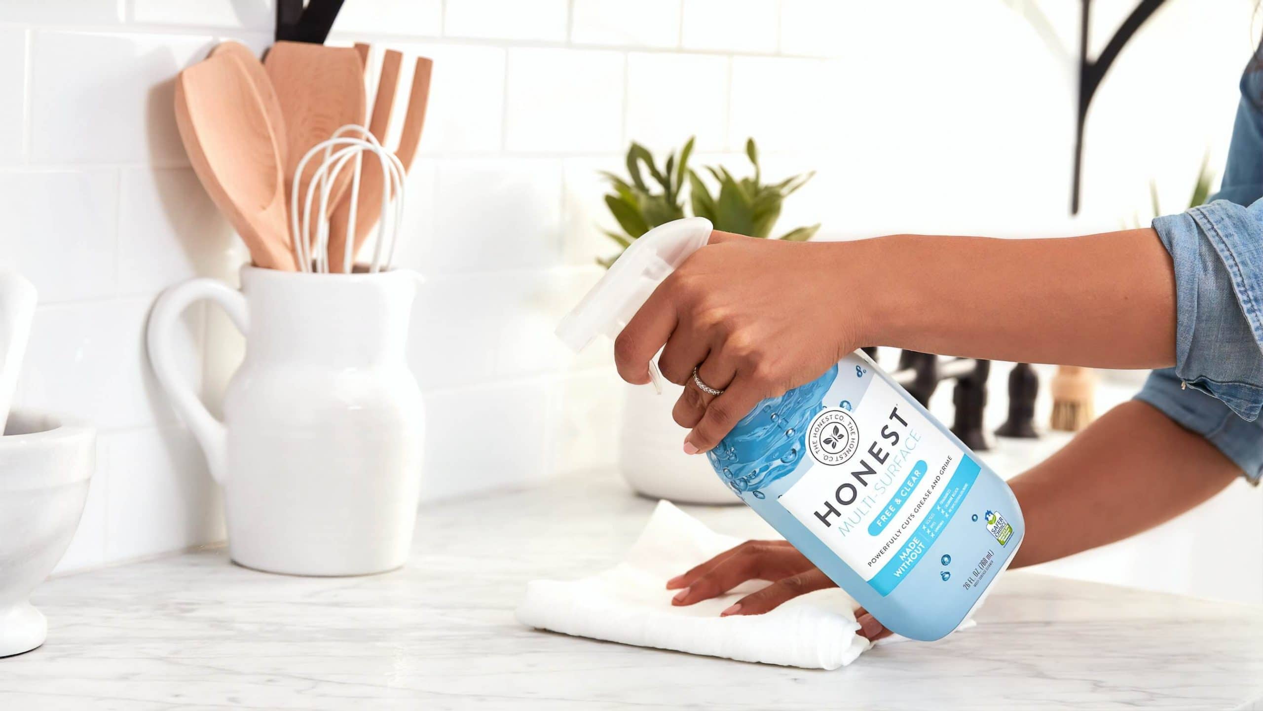 A woman spraying cleaning chemical on the table