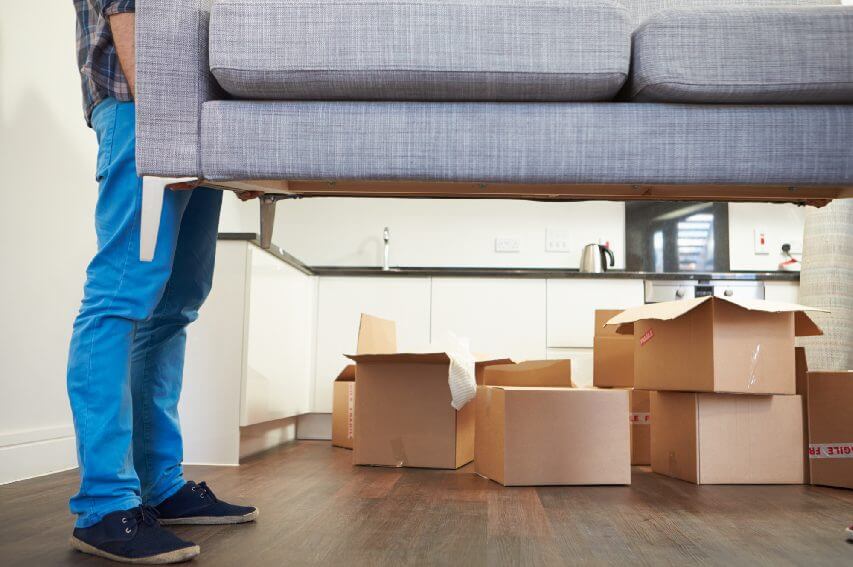 A man lifting a couch