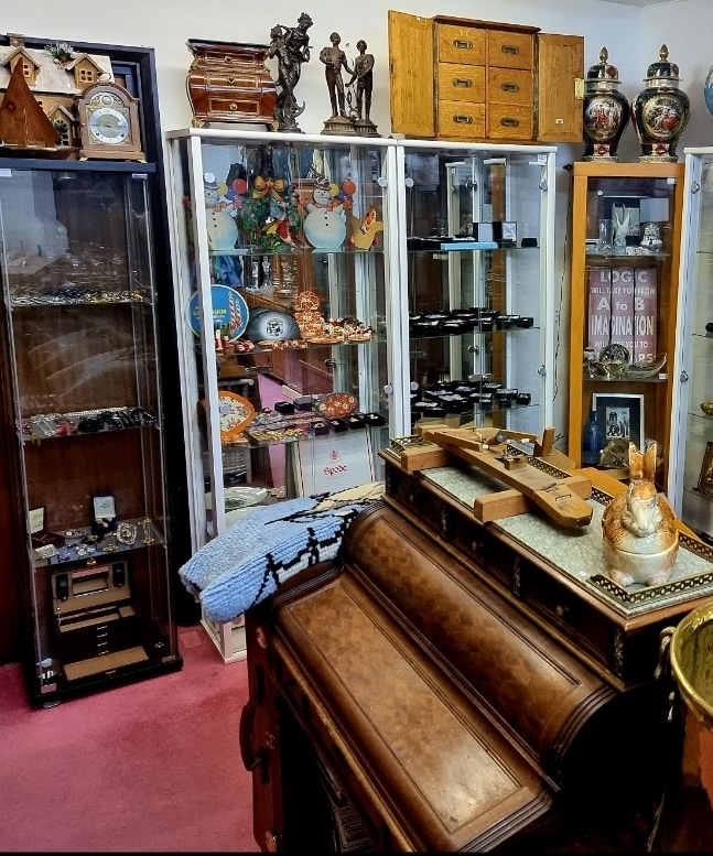 Robinson's Antiques room with glass cases and antique furniture and goods