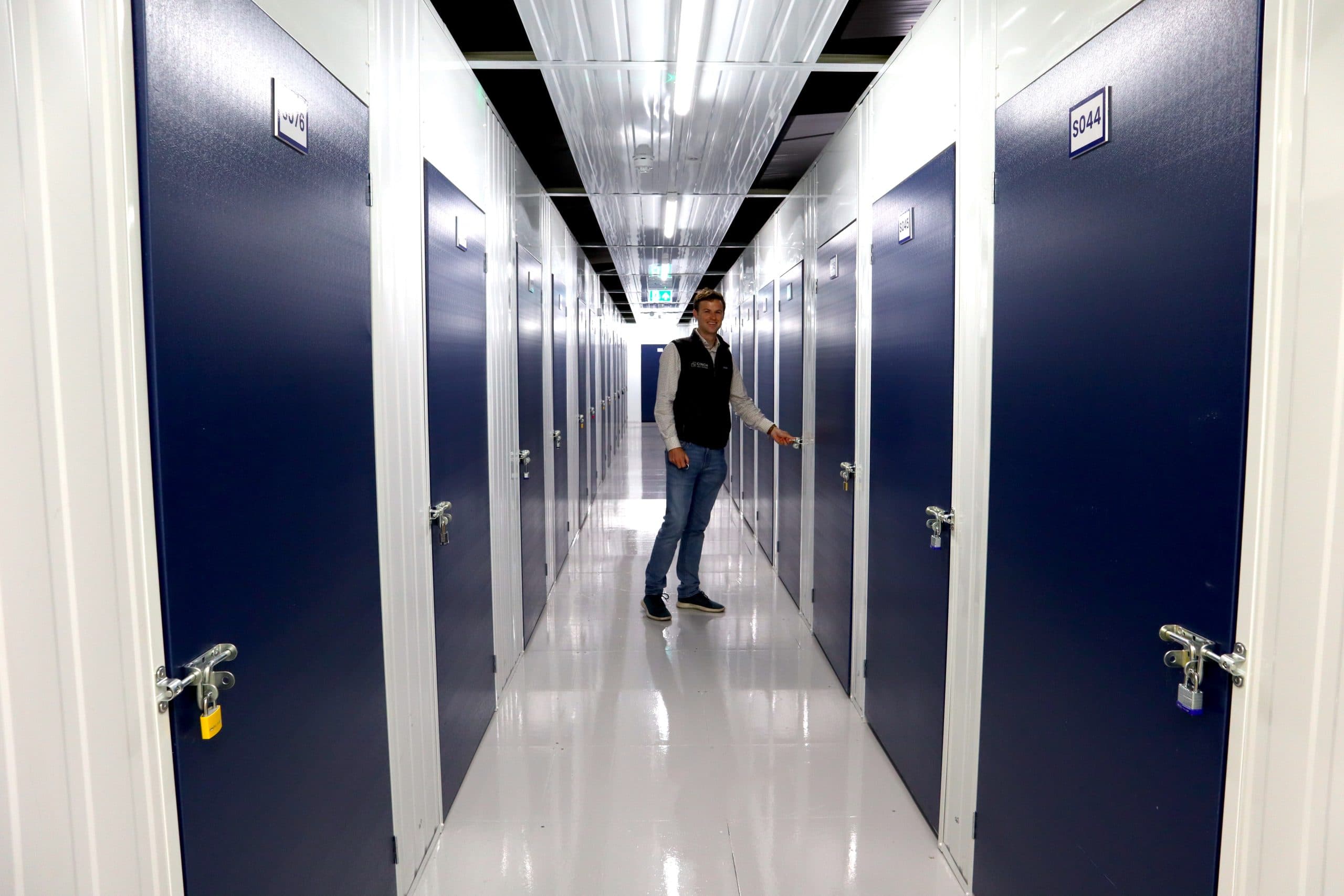 Man walking in corridor of storage units facility Ely