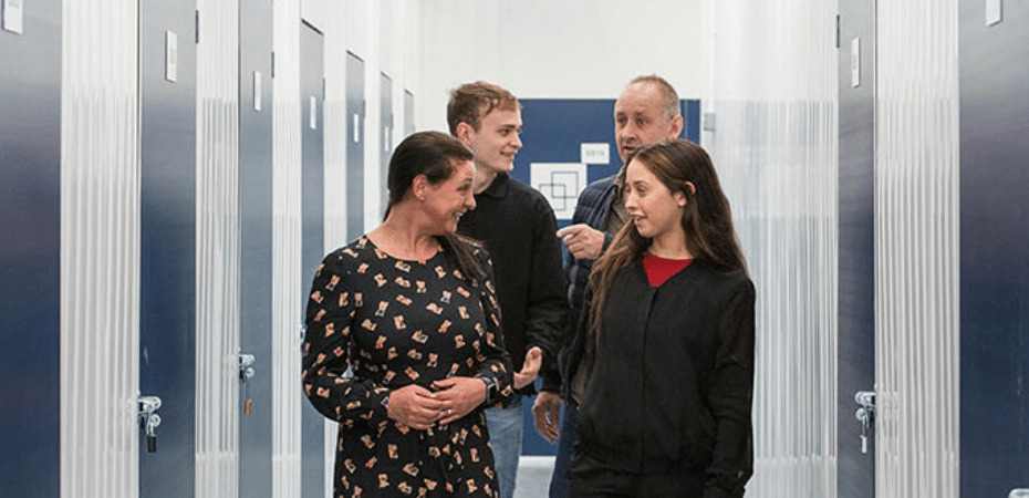 A group of friends talking while walking through a storage facility hallway