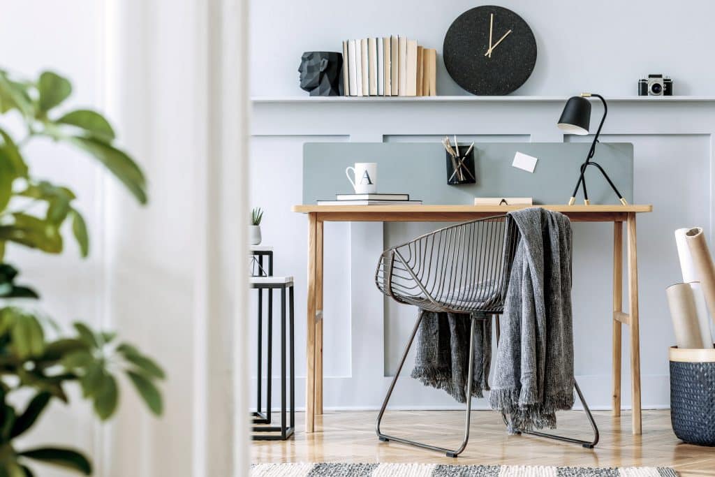 home office staged for a real estate sale with desk, chair and plant 