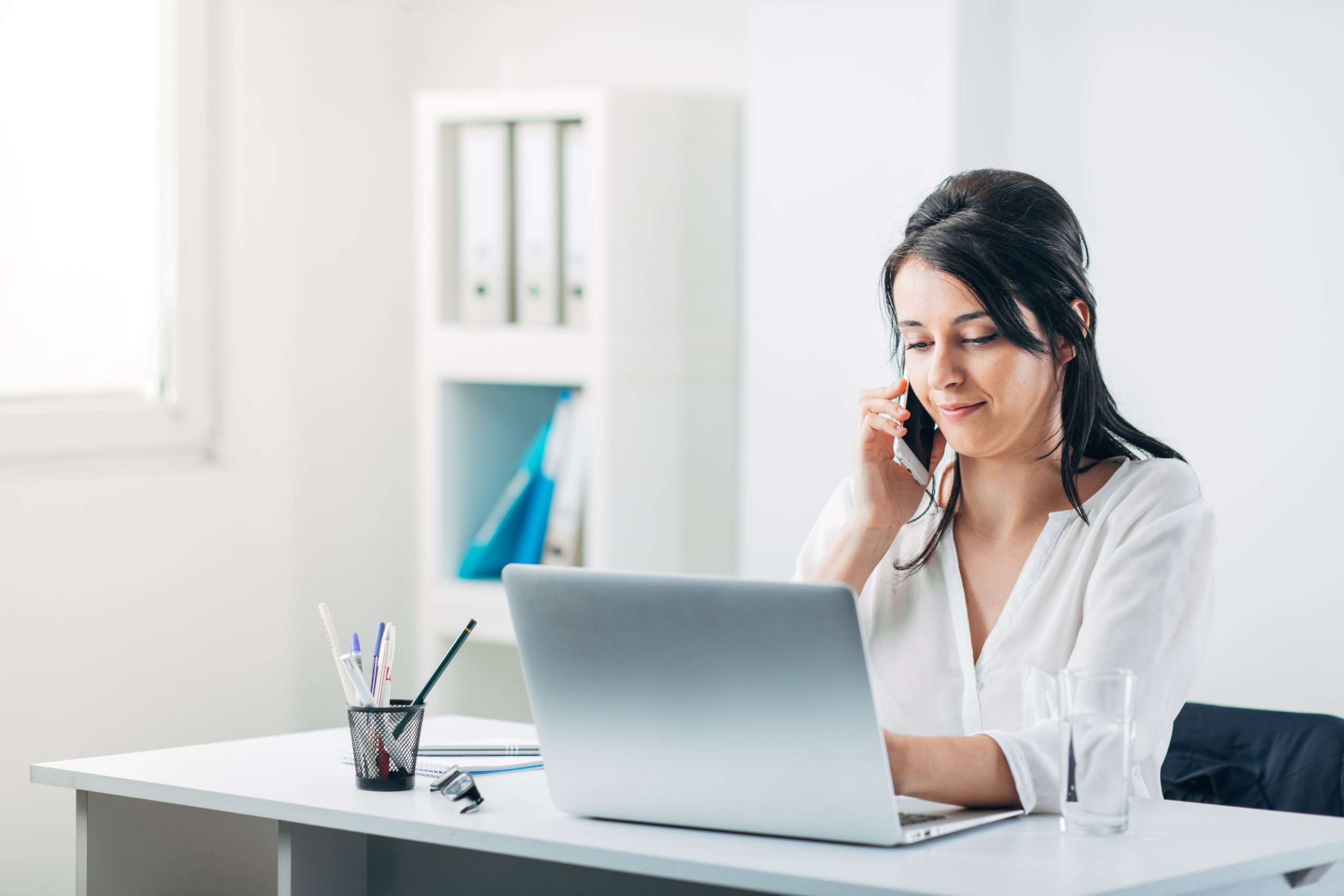 Women on her phone at her desk in her Small office to rent Bicester