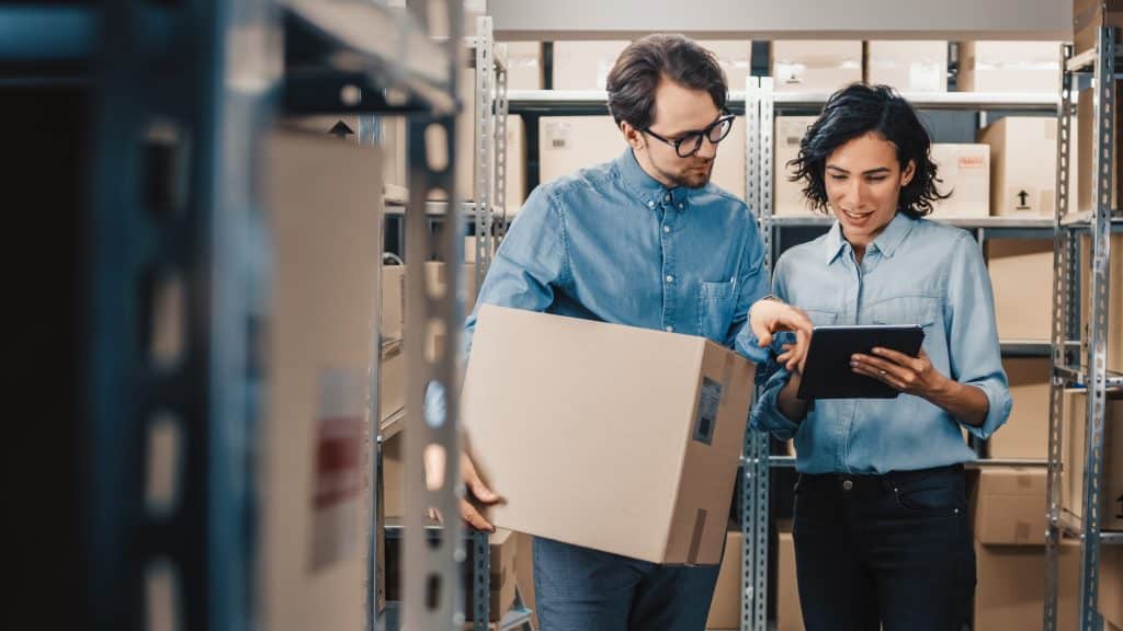 Business couple standing in their business storage space in Bicester with boxes around them