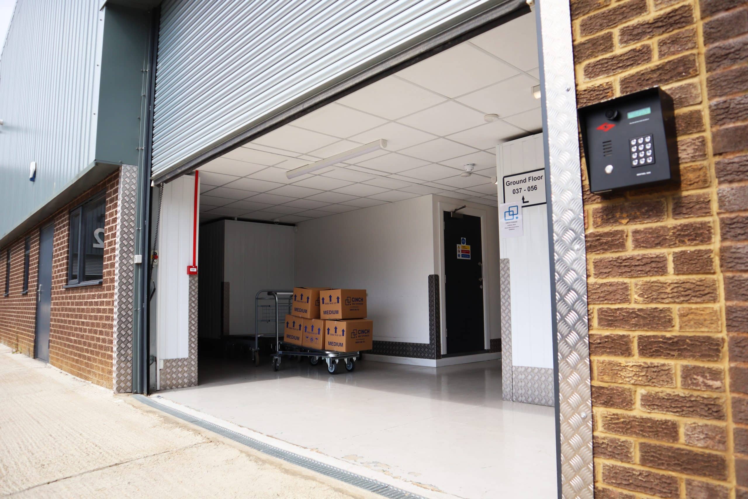 5 benefits of using or self storage Huntingdon UK - image shows an open view from the outside into the interior of the Huntingdon facility with a trolley and boxes