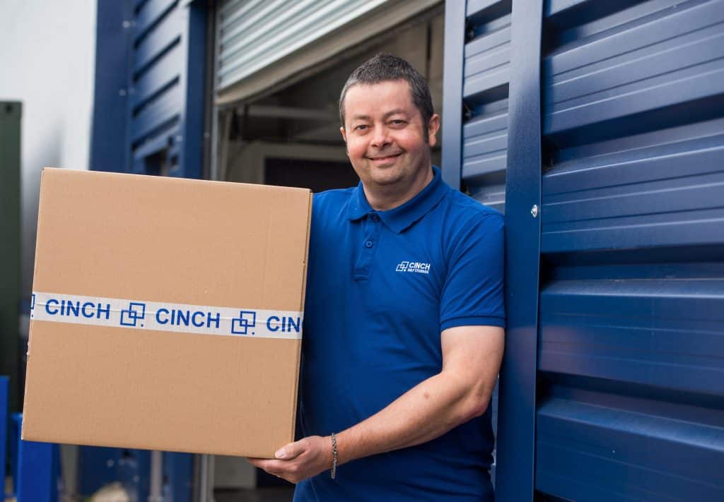 Storage to rent Thatcham - Cinch employee holding Cinch cardboard box outside storage facility 