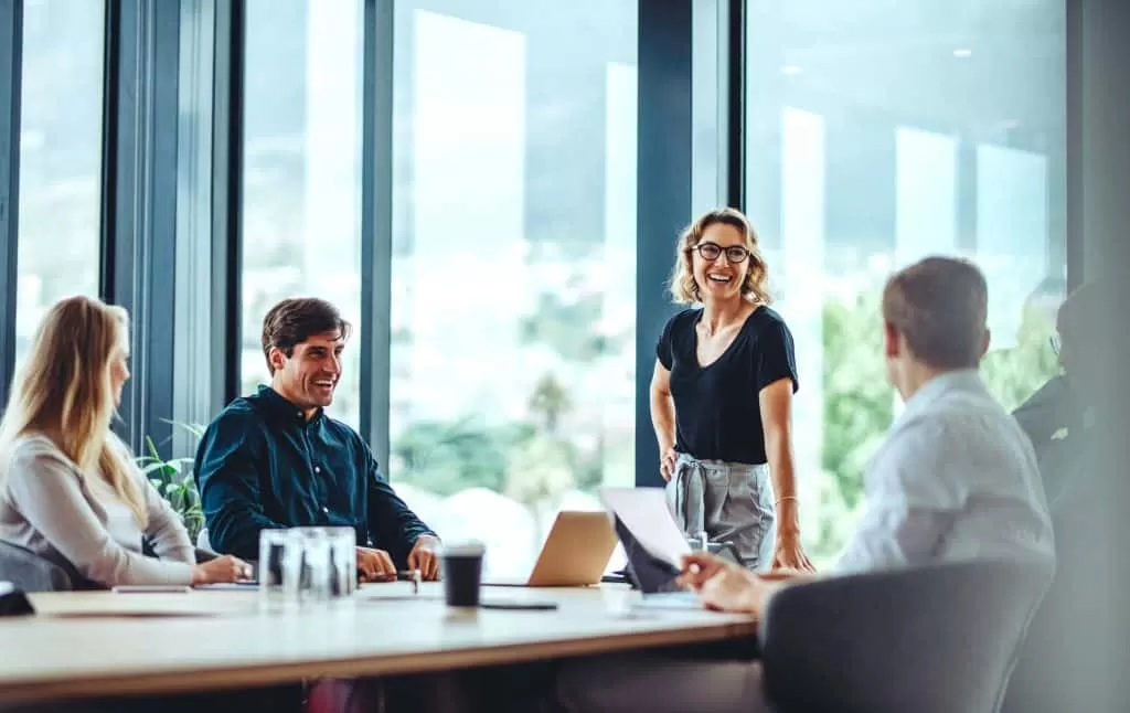 Storage in Newbury - image shows a business group sitting at a table and one woman standing smiling