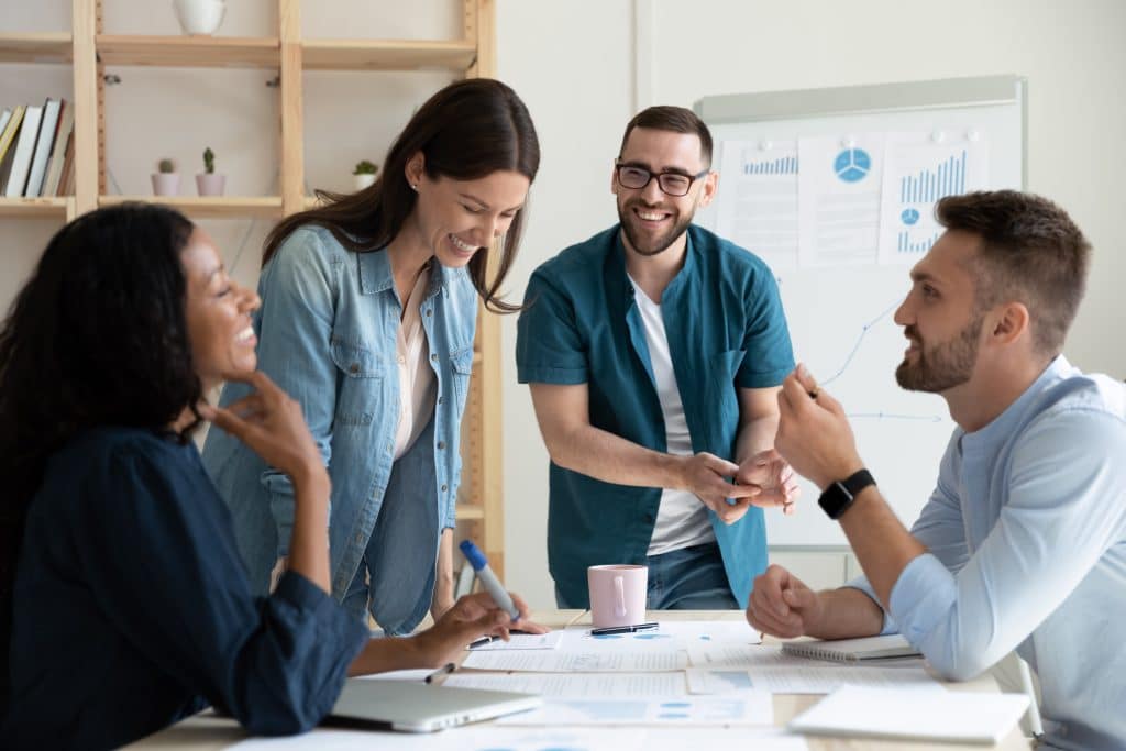 Bring your entire business operation to us with our office to rent Newbury. Image shows 4 people in an office discussing work, a man and a woman are standing and a man and a woman are seated at the desk. 