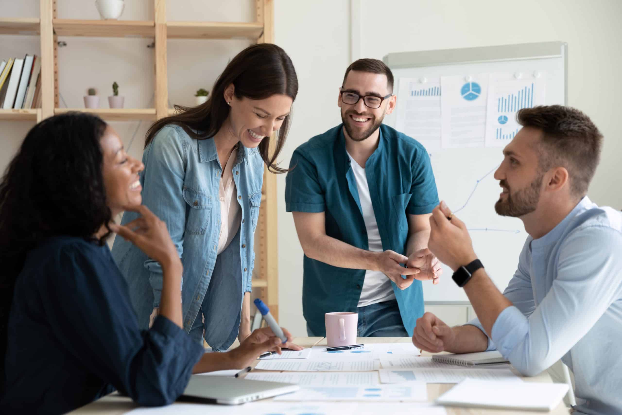 Bring your entire business operation to us with our office to rent Newbury. Image shows 4 people in an office discussing work, a man and a woman are standing and a man and a woman are seated at the desk.