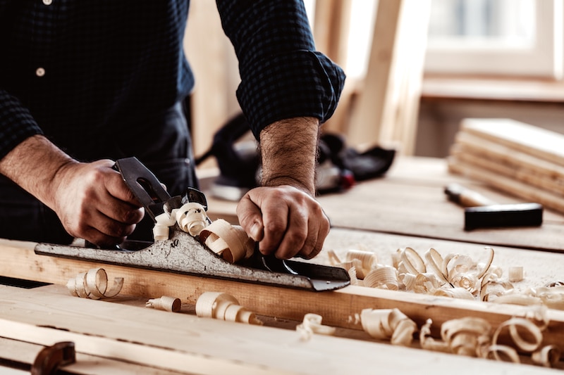 Storage Earlsfield. Image shows woodworker planing a piece of wood.