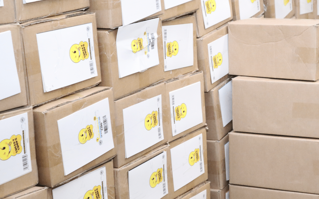 Self storage Newbury UK. Image shows brown boxes with white labels filled with business stock stacked up in a storge unit.  