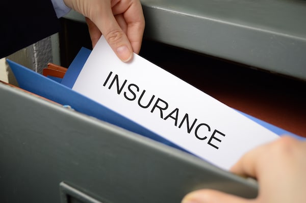 Storage insurance. Image shows an open filing cabinet with a hand holding a folder poking out of the file with the word 'Insurance' written on it.