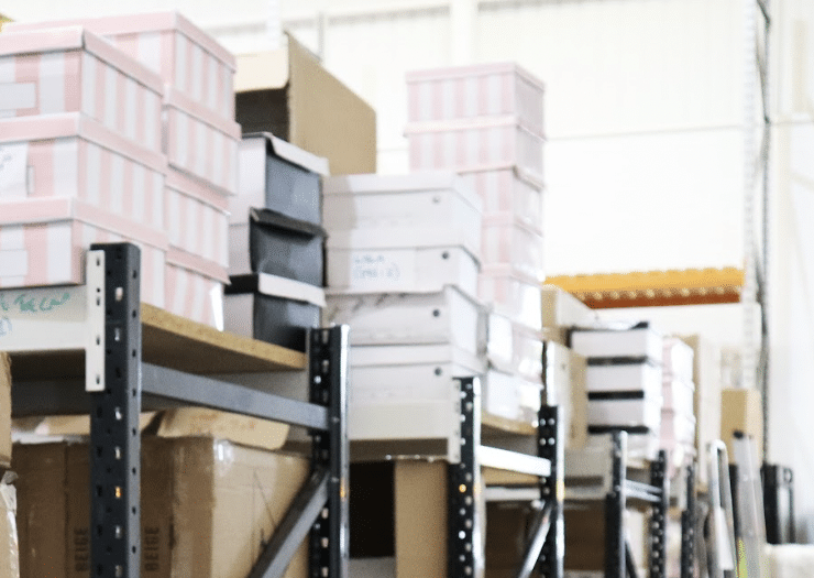 watford_business_storage. Image shows business stock in striped pink and white boxes stacked on top of shelf racking in a storage unit. 