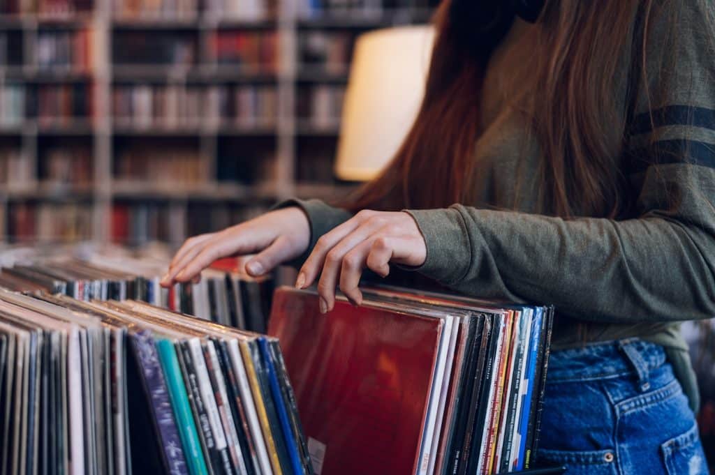 How to store Vinyl records? 10 Top tips. Close up of a woman hands choosing vinyl record in music record shop. 