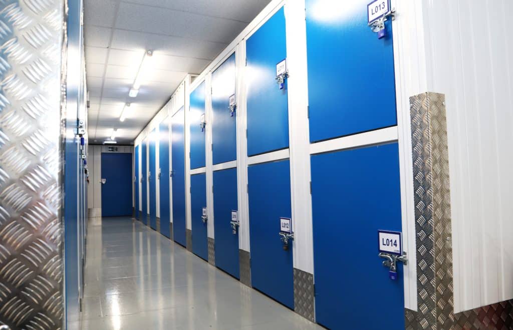 Short term vs long term storage. Image shows two-tiers of small storage units on a white wall with blue doors. 