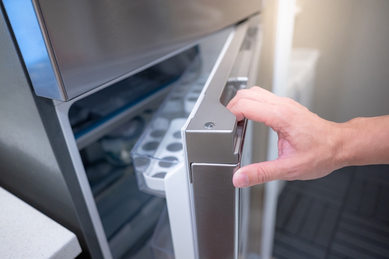 How to store a fridge. Image shows a male hand opening fridge door