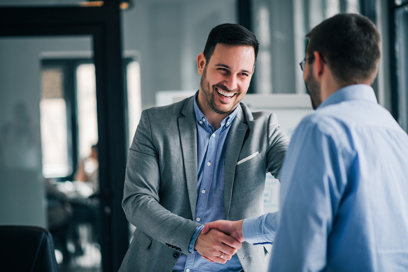 House move storage Dunstable. Image shows A cheerful young manager shaking hands with new employee.
