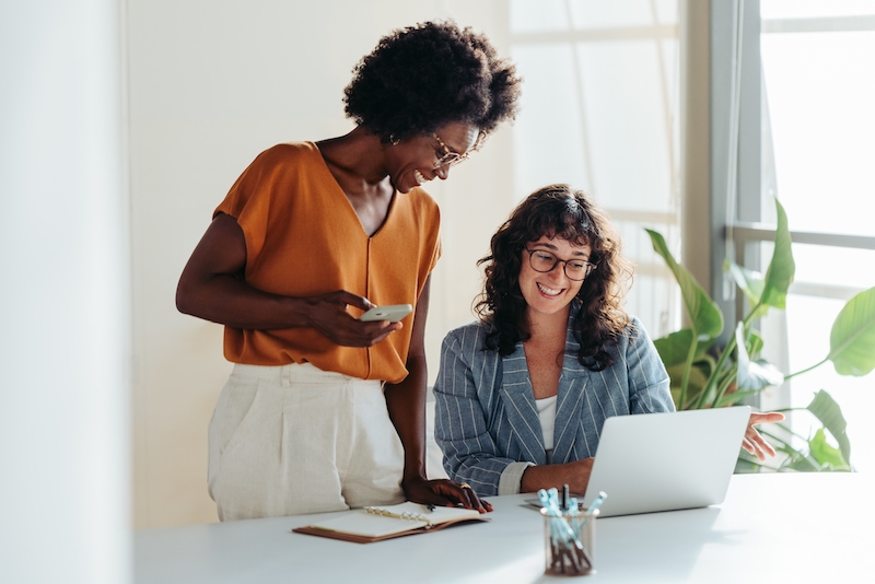 Serviced office Bedford. Image shows two women looking at a laptop in their office.