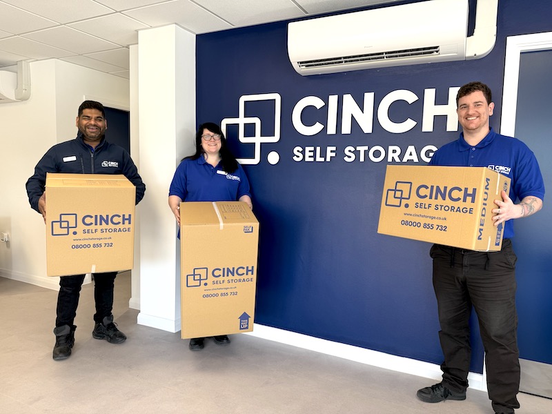 Storage near Swindon. Image shows Cinch Self Storage employees holding Cinch storage boxes.